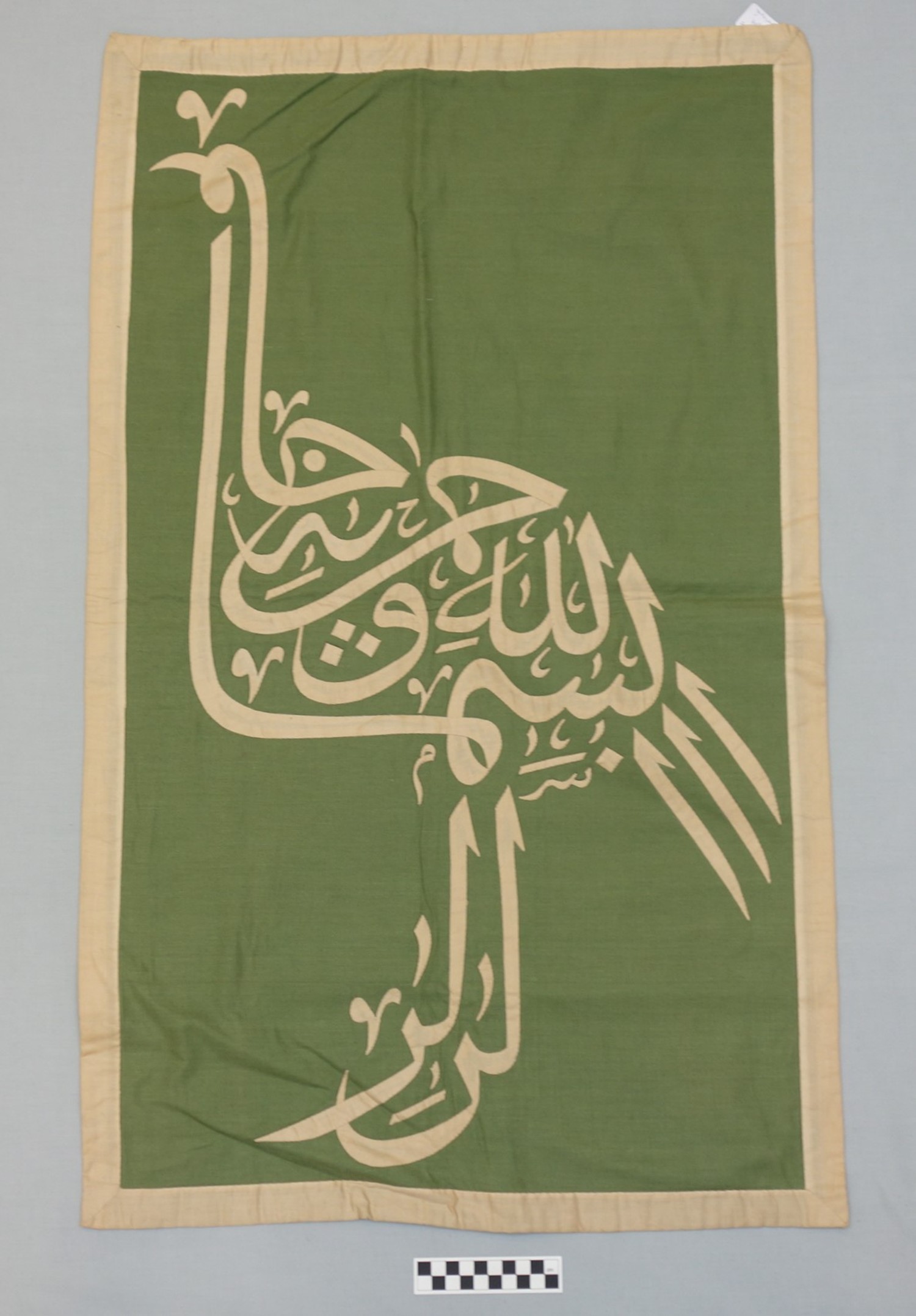 Appliqu&eacute; panel from the Street of the Tentmakers, Cairo, Egypt (TRC 2014.0818), showing a text written in the shape of a bird. For more information, click on the illustration.