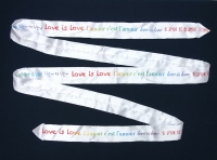 LGBTQ+ tie designed for World Pride 2019, with slogan &ldquo;Love is love&rdquo; in six languages, by Ty-Amo. (USA).