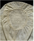 A late 18th century linen child&rsquo;s cap decorated with a band of hollie point