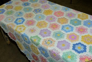 Example of a quilt with the Grandmother's flower garden pattern.