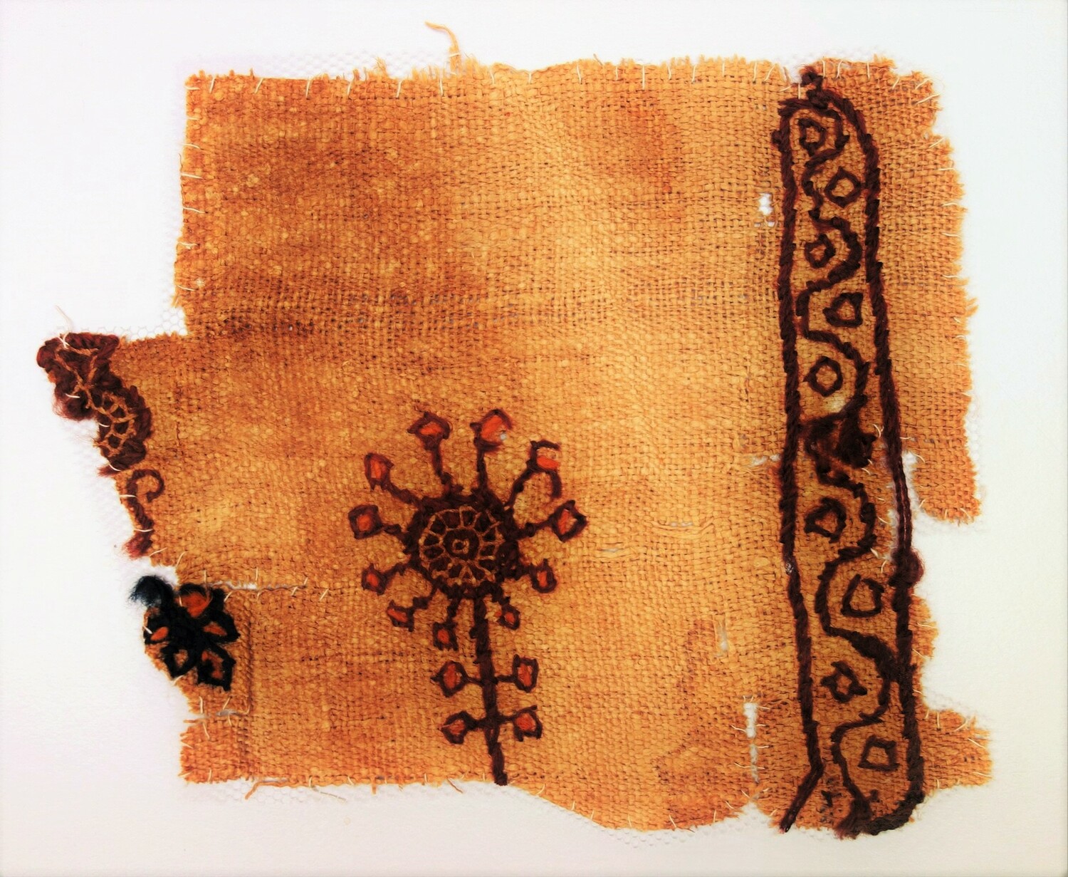 Fig. 2. Fragment of linen with an embroidered design worked in purple, orange and blue wool, probably from a child's tunic. Egypt, 5th-6th century AD (TRC 2000.0015).
