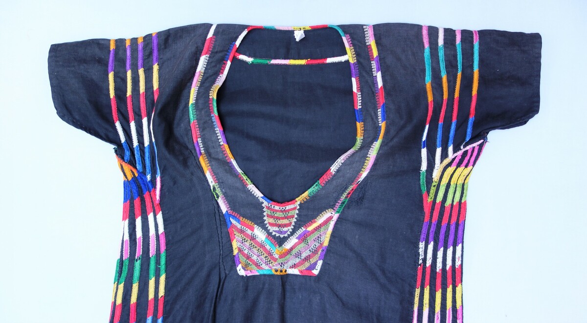 Detail of a dress from Irbid, in the north of Jordan, from the 1930's. The neckline is decorated with satin stitch and rekme embroidery (TRC 2005.0140).