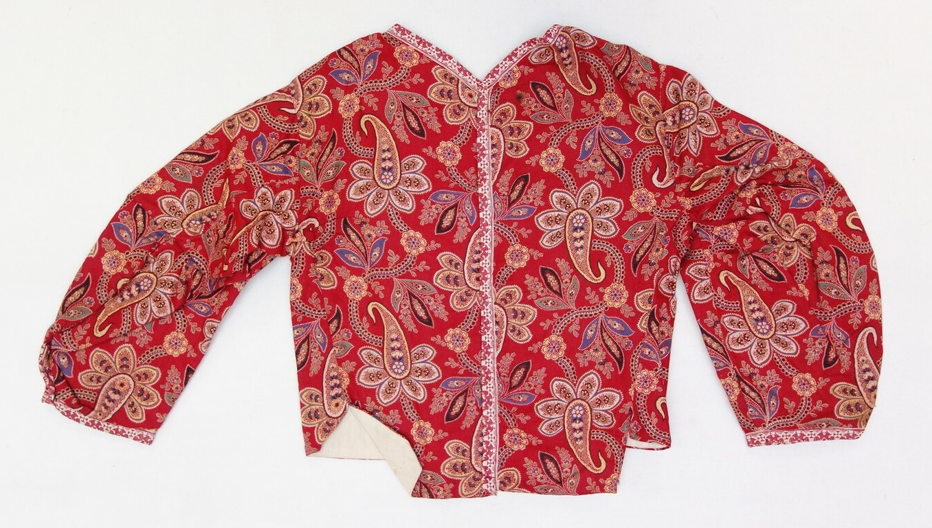 A jacket made from a red cotton cloth decorated with a multi-coloured floral and paisley pattern. From the island of Marken, The Netherlands, 1937 (TRC 2007.0525c).
