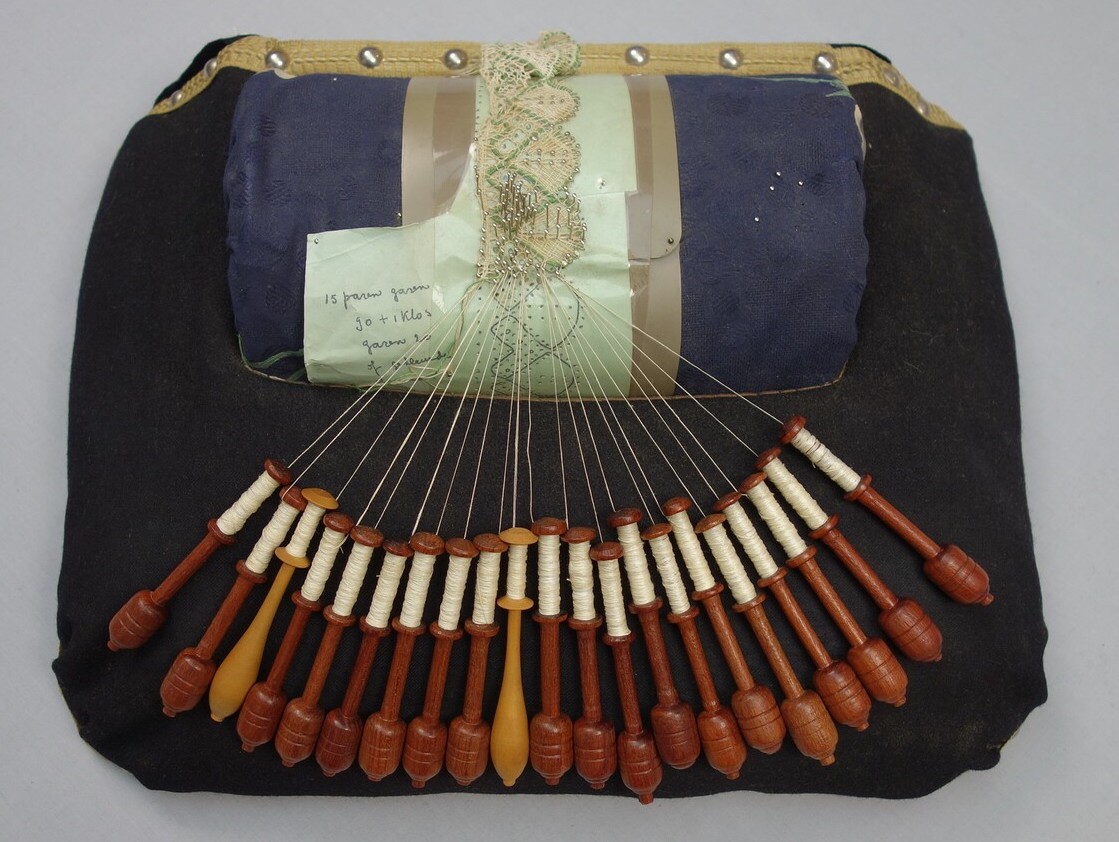 Lace pillow with bobbins and sample of torchon lace, Belgium (TRC 2012.0009).