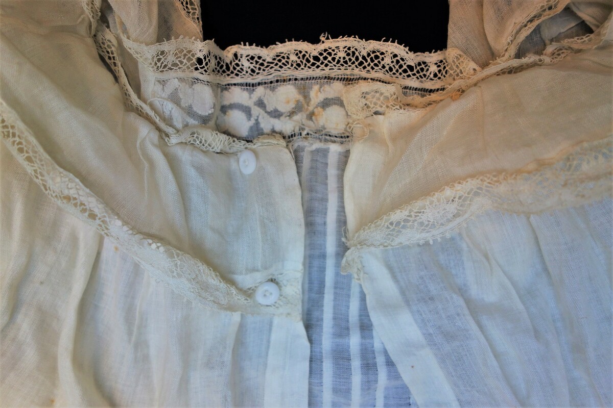 Detail of an early 20th century baptismal gown from Friesland, the Netherlands, with shadow work embroidery in herringbone stitch along the collar (TRC 2019.0028).