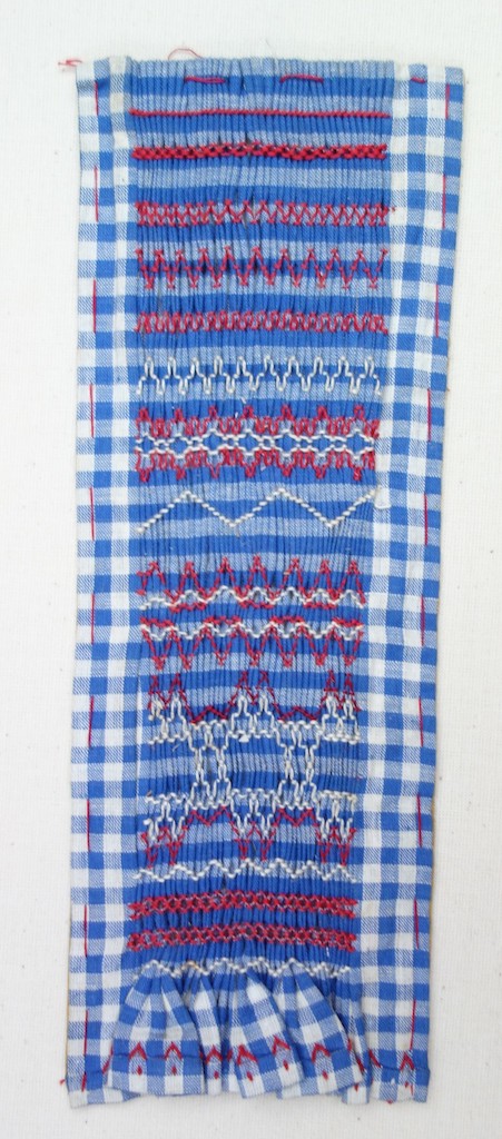 A sample of smocking using a blue and white gingham material as the ground. The sample was made by Grethe la Croix (1906-2001), a famous Dutch artist, designer and embroiderer (TRC 2020.0481). 