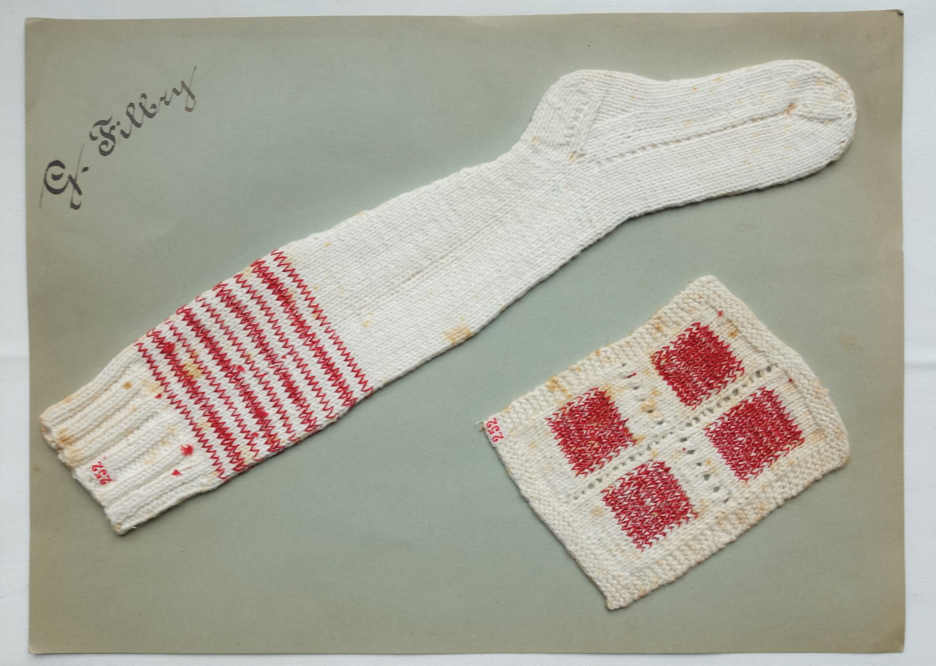 Knitted miniature sock and mending panel, worked by G. Filbry between 1928 and 1930 (TRC 2020.3838d).