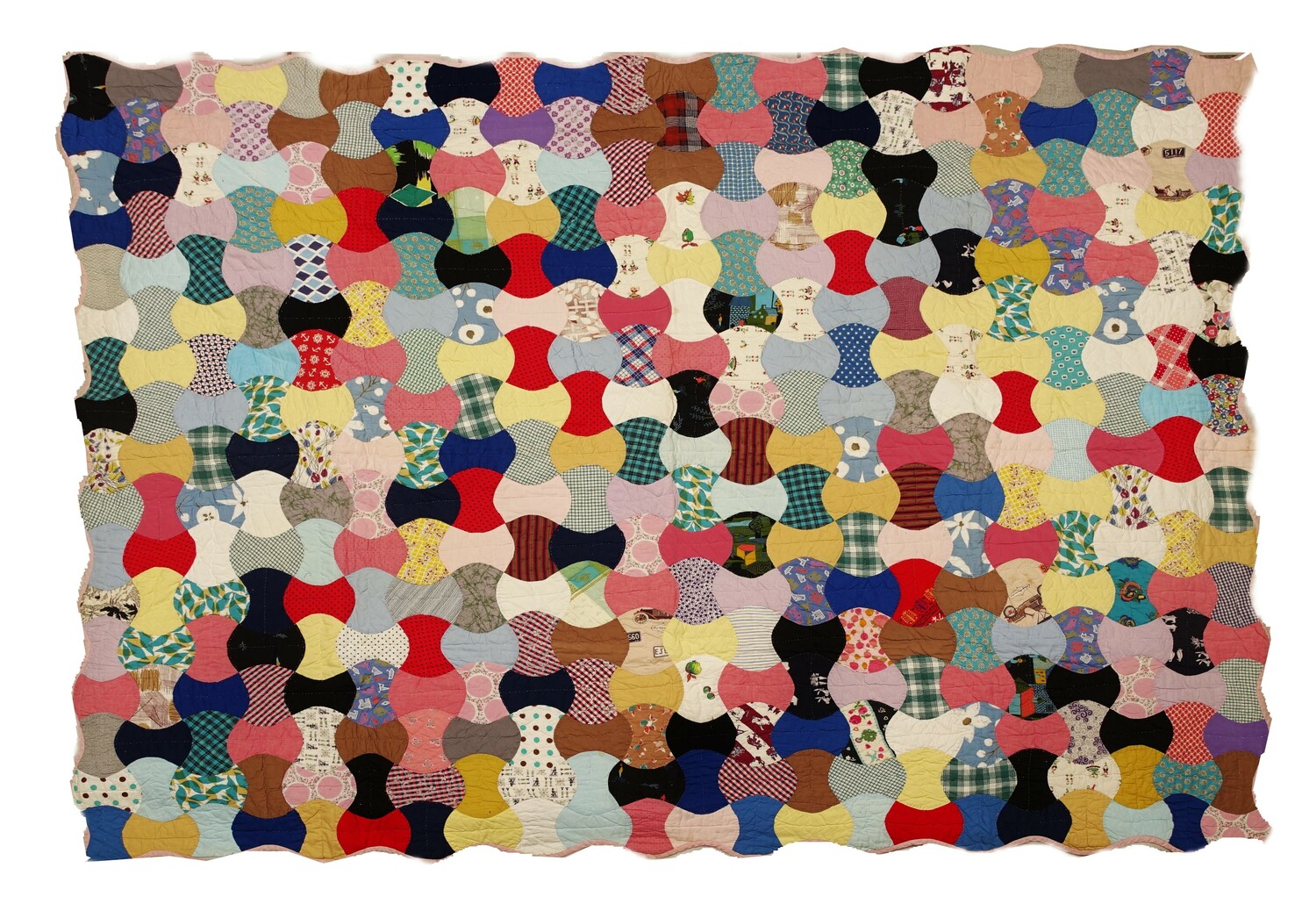 Large quilt with a top made from connecting 'apple core' blocks in a wide variety of plain, textured and printed materials. USA, 20th century (TRC 2022.0987).