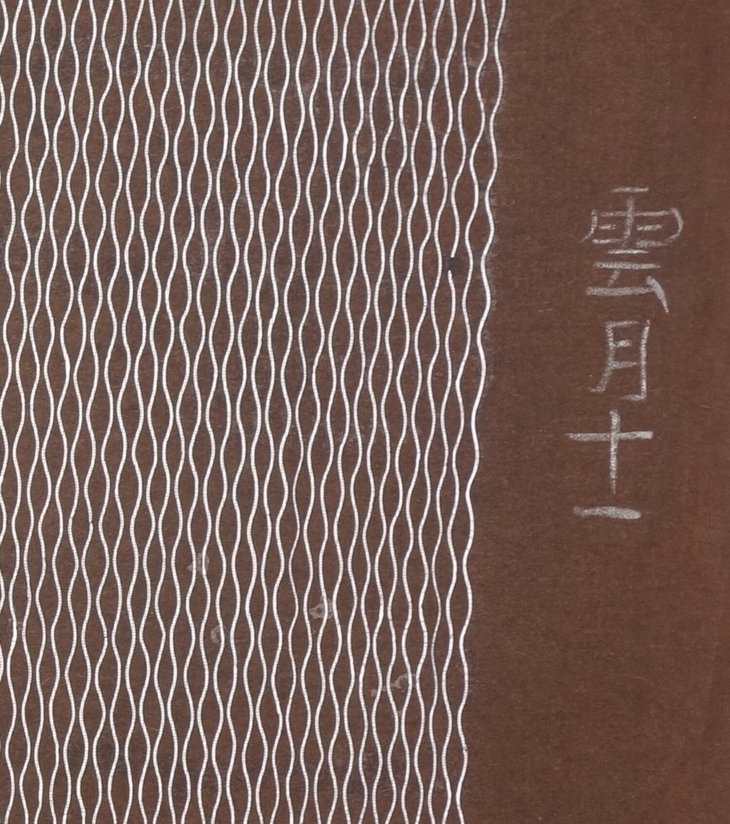 Detail of a stencil with a repeating pattern of paired wavy lines. The other side of the stencil has been strengthened with an open weave silk cloth. Japan, 20th century (TRC 2024.2023).