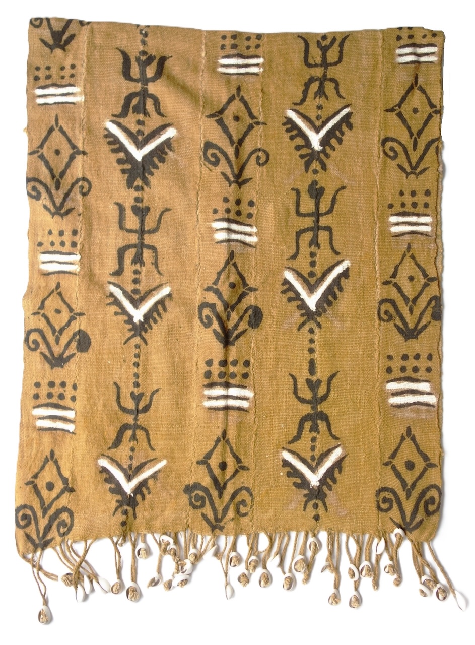 Length of cloth made from strips (15 cm) of woven cotton, dyed brown and then painted with various motifs. The fringes are decorated with white cowrie shells. Mali? (TRC 2026.2254).