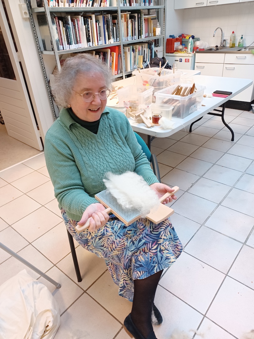 Gillian happily carding wool. Photograph by author.