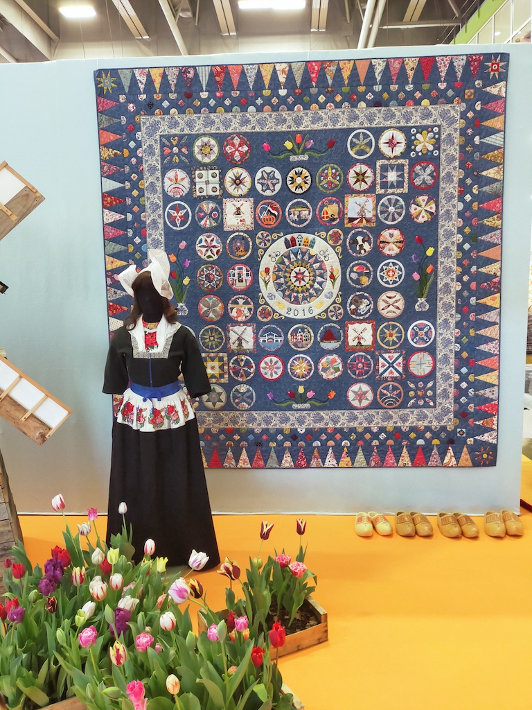Volendam mannequin against the background of a quilt with Dutch-inspired designs. Nantes, April 2023.