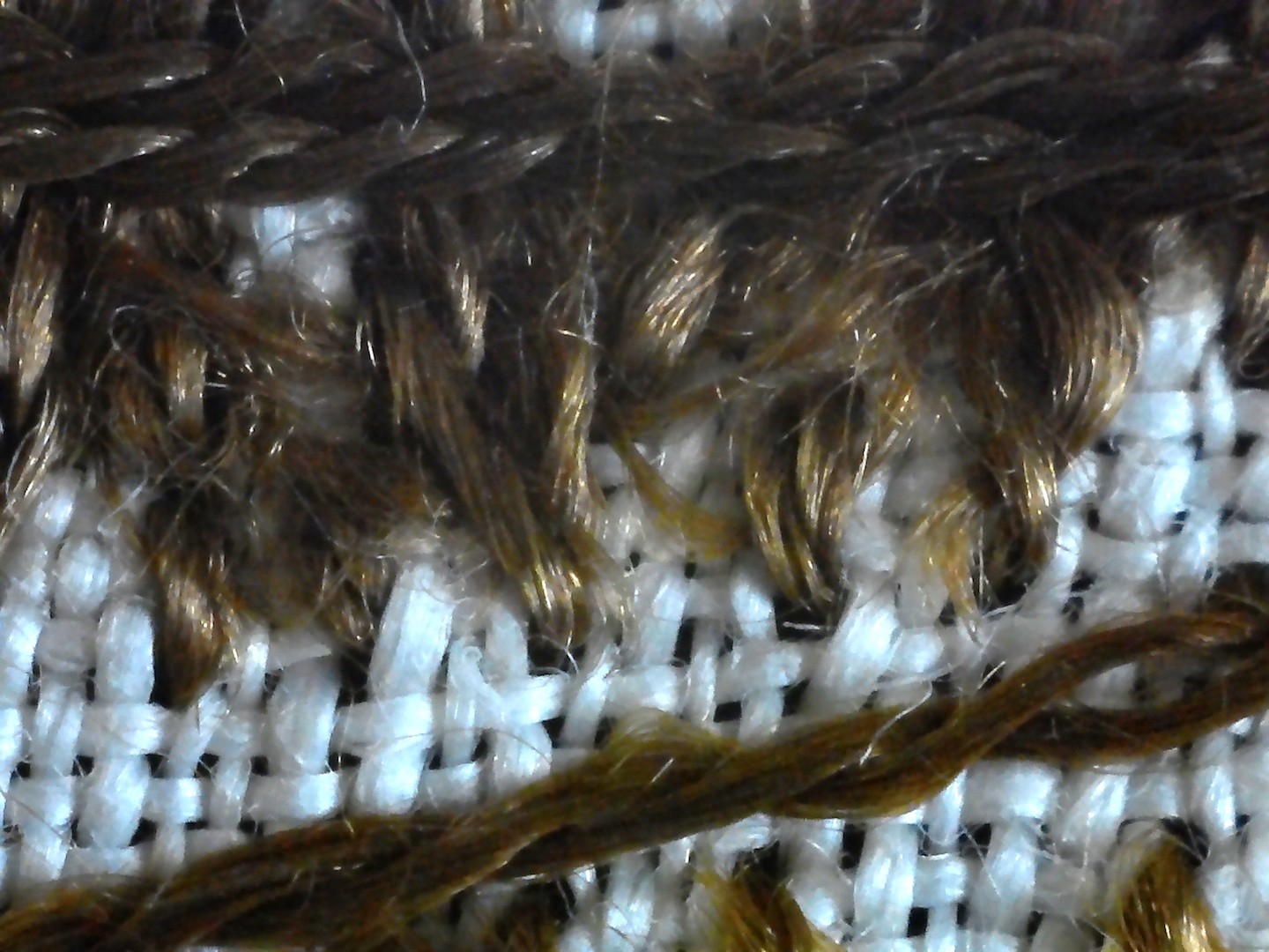 Detail showing the reverse side of the cross stitch stitching, and the ply of the brown silk thread.