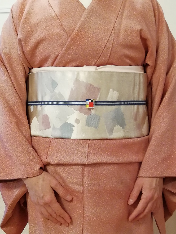 Woman wearing kimono with sash (obi), fastened with a cord that itself is fastened with an obi-dome (TRC 2022.0232).
