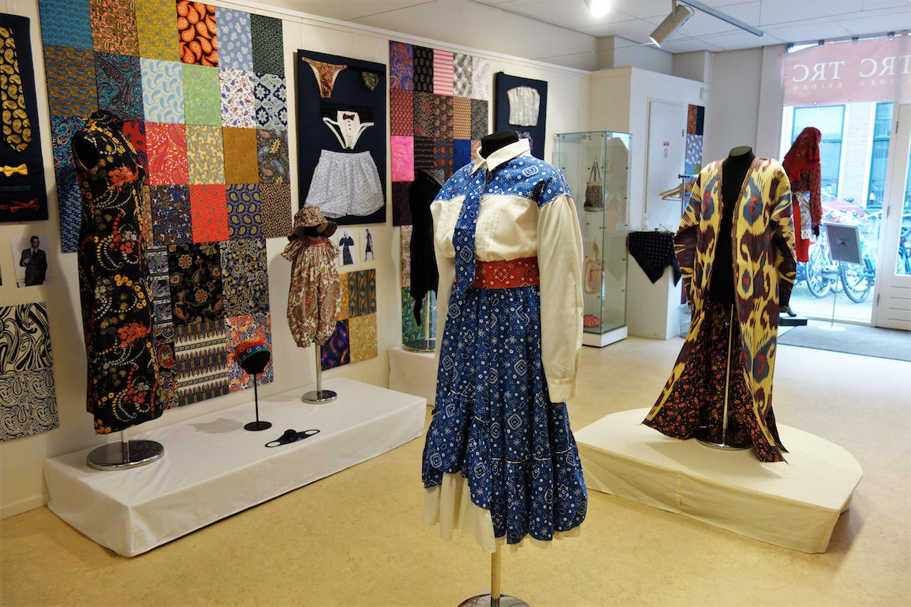 A US line dancing outfit, an Uzbek coat, a Chinese-style cheongsam dress, a baby’s rompers, men’s underwear, a biker’s bandanas and corsets. Plus part of the paisley mosaic on the wall.