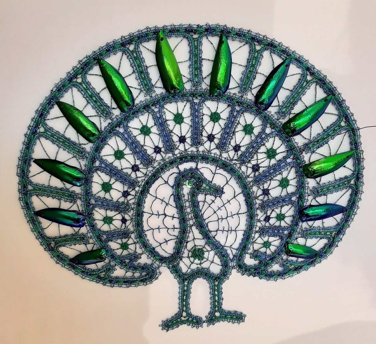Piece of bobbin lace decorated with beetlewings, worked by Ria Heemskerk.