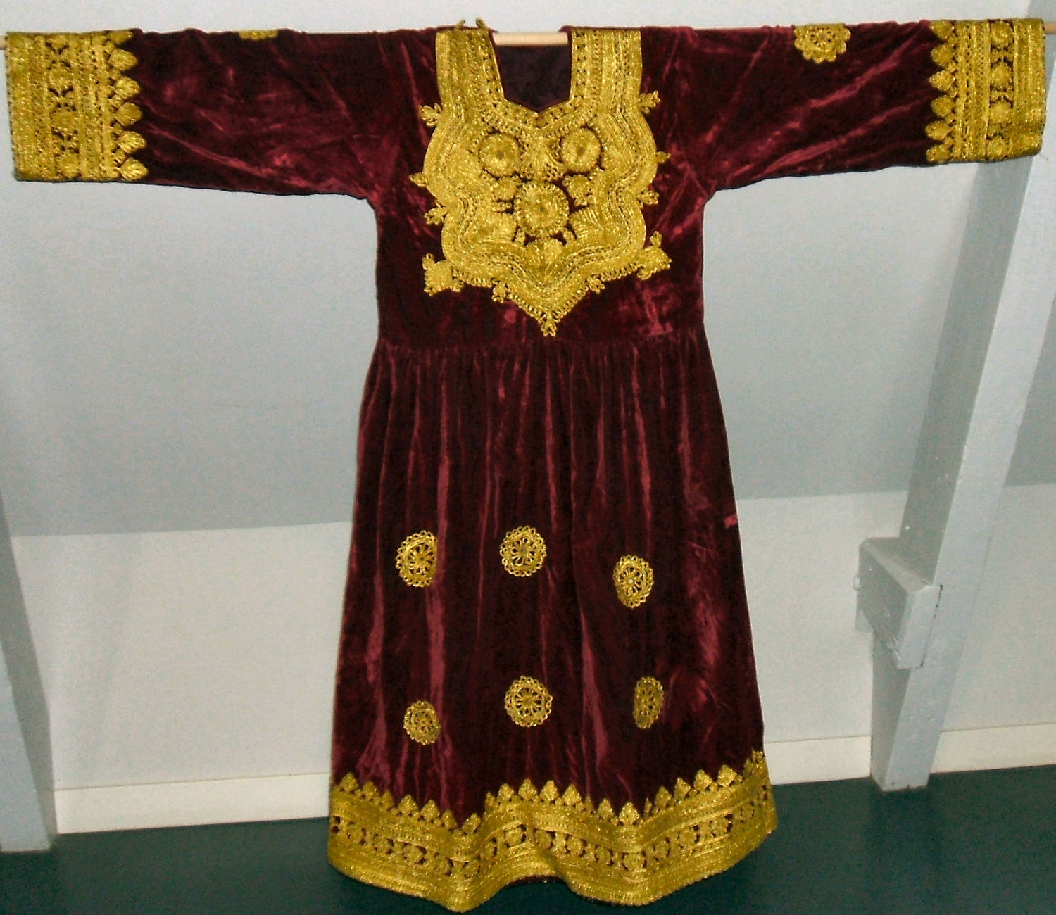 Pashtun dress. TRC 2007.0273b. Factory woven ground cloth with applied metal thread braid (passementerie).