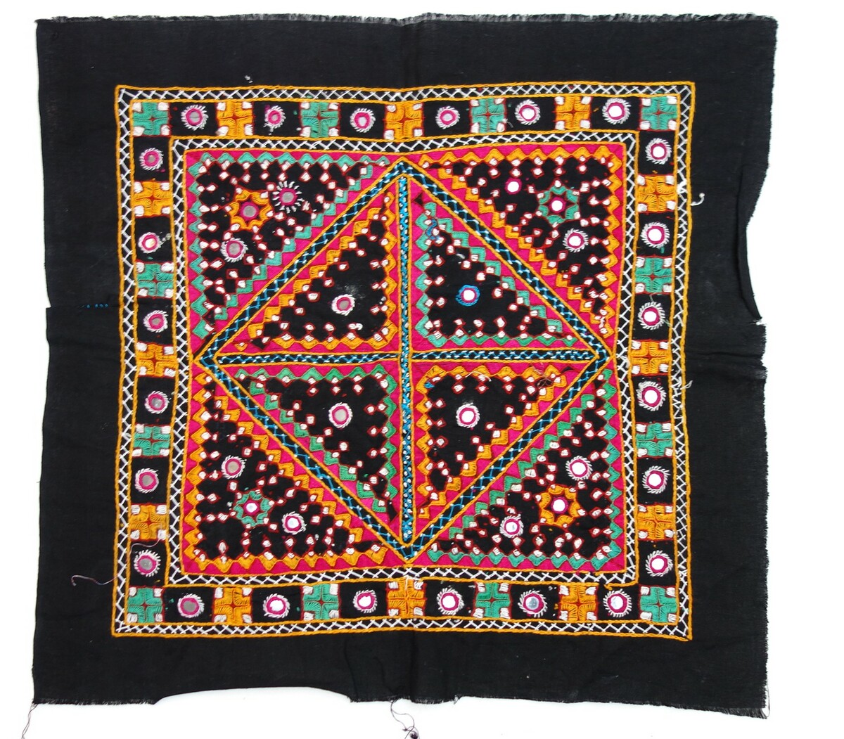 Voorbeeld van geborduurde zwarte katoenen stof met een vierkant ontwerp met verschillende onderling verbonden geometrische vormen en toegepaste spiegels. Fabrieksgeweven doek, handborduurwerk (dekensteek, steelsteek, kettingsteek, visgraatsteek). India, eind 20e eeuw (TRC 2019.0286).