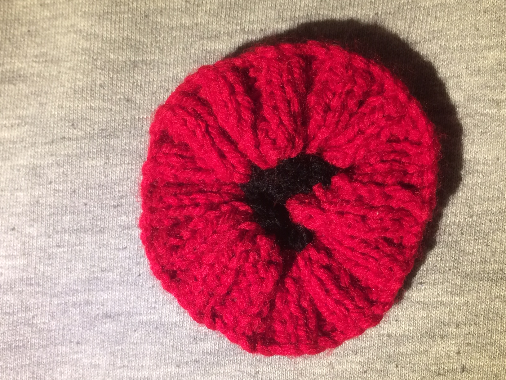 Knitted poppy to commemorate the end of the First World War, bought in Helsby, UK, November 2019.