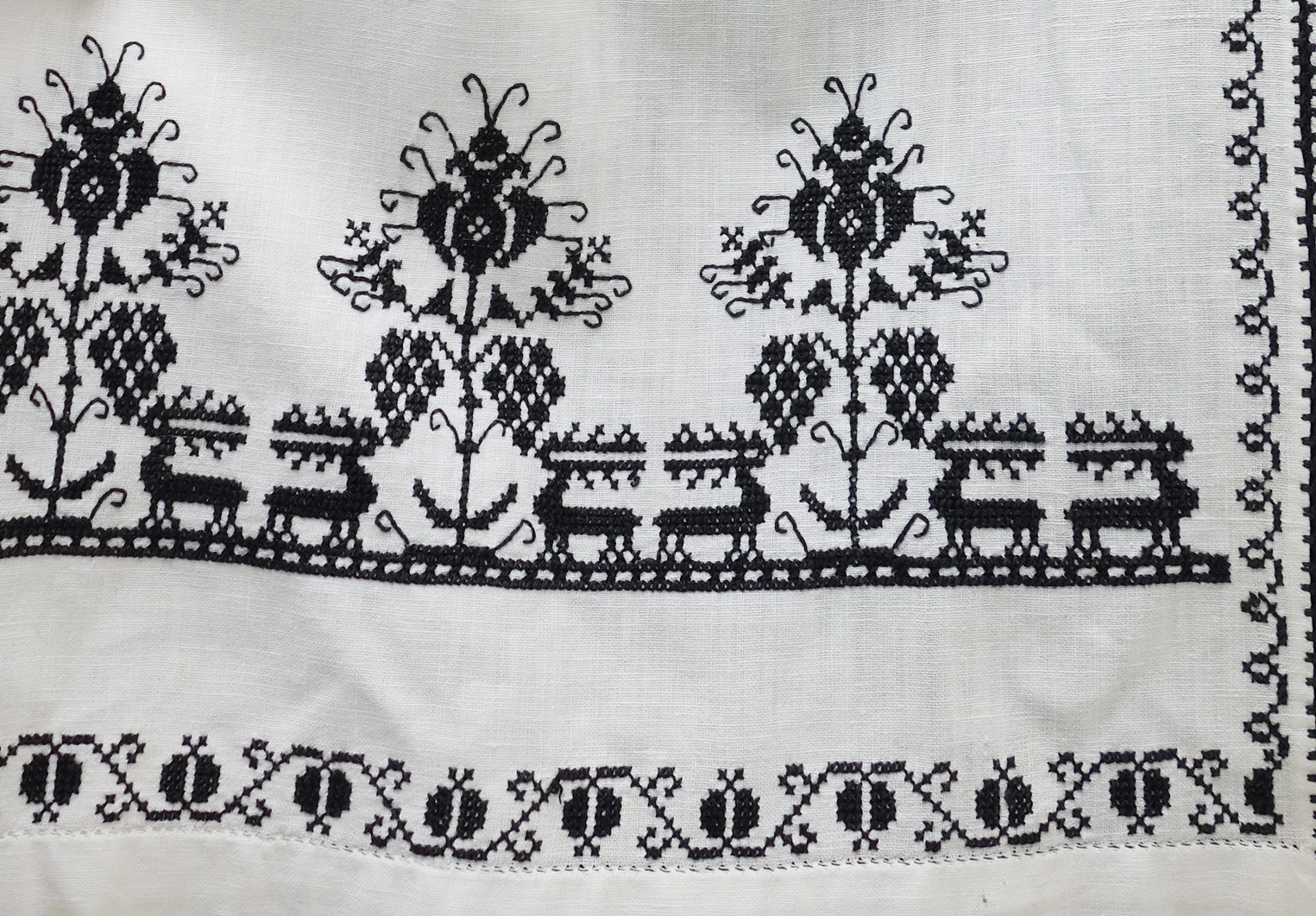 Detail of an East European apron with an embroidered deer design, 1960's (TRC 2016.0889e).