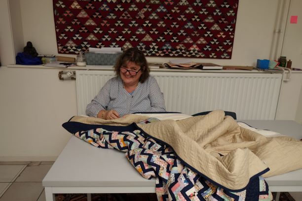 Beverley Bennett sewing on sleeves for the quilts (TRC October 2018).
